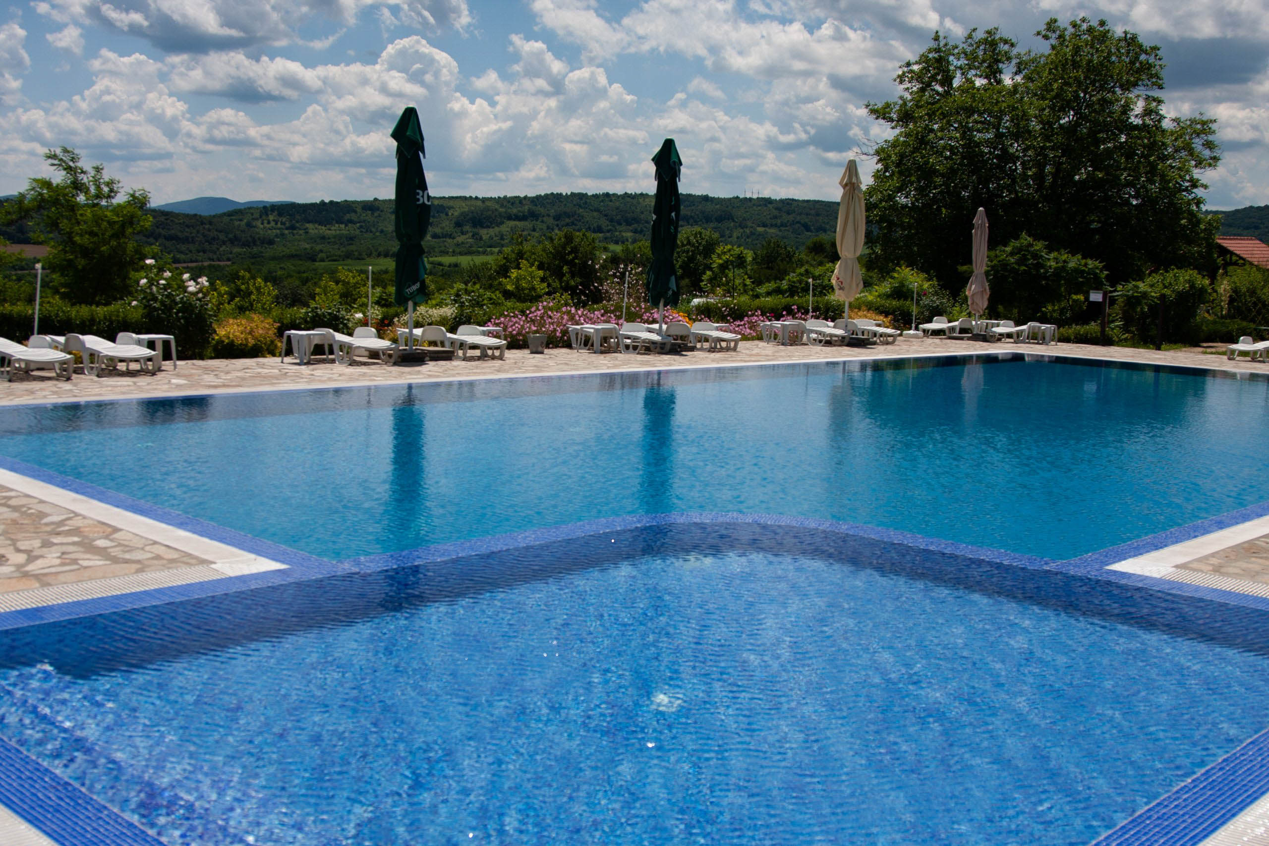 Swimming Pool Terrace with Sunbeds and flowers at Camping Veliko Tarnovo, Bulgaria.
